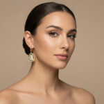 Aretes dorados Lirio de ZYRAL en modelo